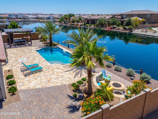 view of swimming pool with a patio, a water view, fence, and a residential view