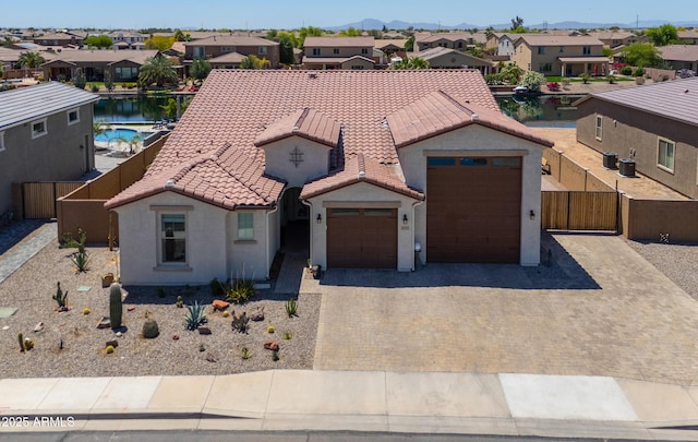 mediterranean / spanish-style home featuring a tiled roof, stucco siding, driveway, and a residential view