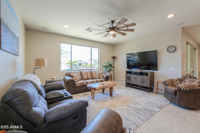 living room with recessed lighting, light wood-style flooring, ceiling fan, and visible vents