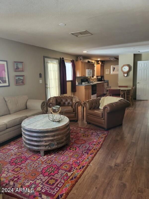 living room featuring dark hardwood / wood-style floors and a textured ceiling