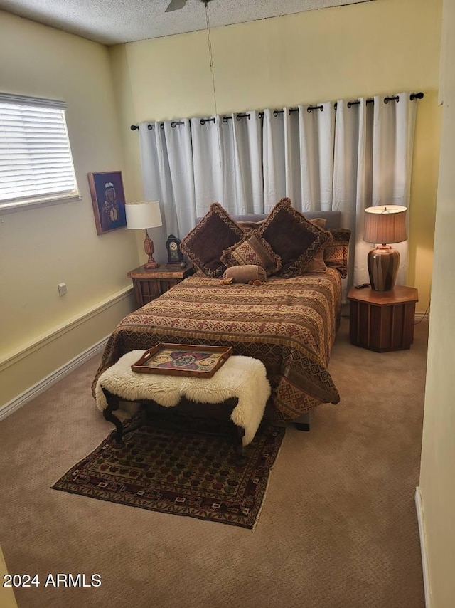 bedroom featuring ceiling fan, carpet, and a textured ceiling