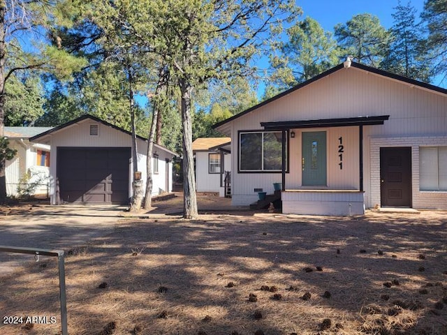 view of front facade featuring an outbuilding, a porch, and a garage