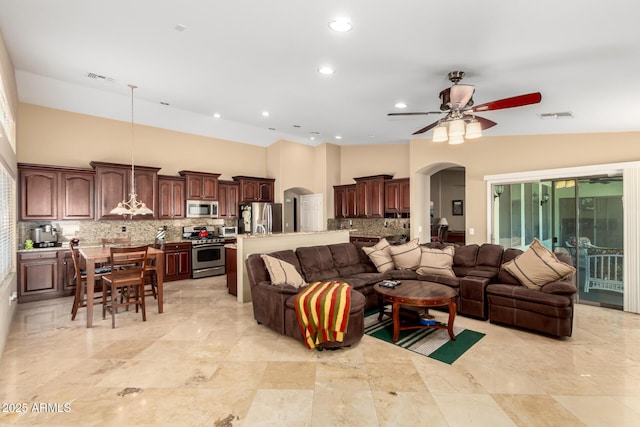 living room featuring arched walkways, recessed lighting, visible vents, a healthy amount of sunlight, and a ceiling fan