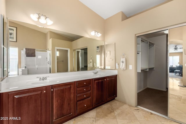 full bath with double vanity, a stall shower, a sink, and tile patterned floors