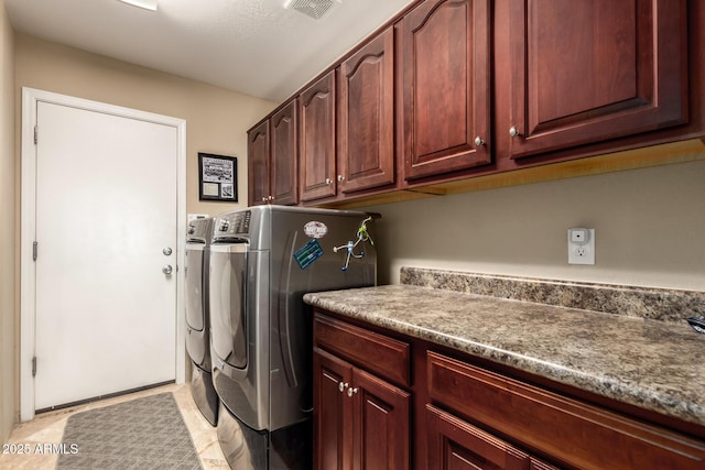 laundry room with washing machine and dryer, cabinet space, and visible vents