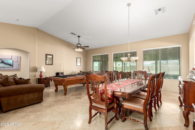 dining space with lofted ceiling, ceiling fan with notable chandelier, and visible vents