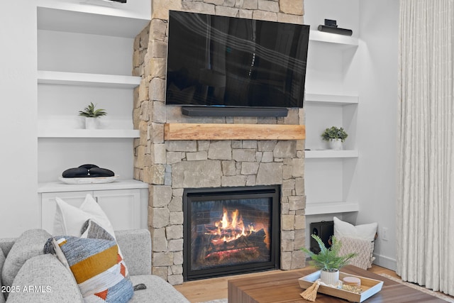 living room with hardwood / wood-style floors, a fireplace, and built in shelves