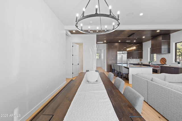 dining space featuring hardwood / wood-style flooring, sink, and a notable chandelier