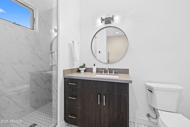 bathroom featuring vanity, a shower with shower door, and toilet