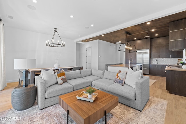 living room with a chandelier and light wood-type flooring