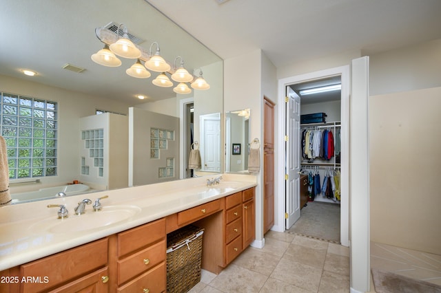 bathroom with a tub, tile patterned flooring, and vanity