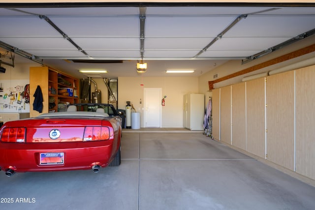 garage featuring white fridge and a garage door opener