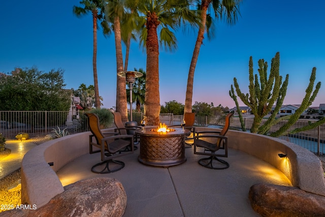 patio terrace at dusk featuring an outdoor fire pit