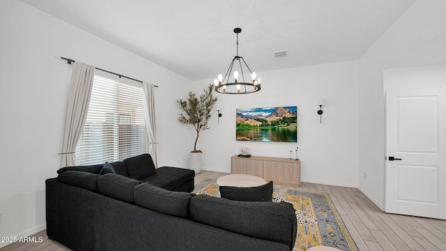 living room featuring visible vents, a notable chandelier, light wood-style flooring, and baseboards