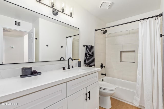 full bathroom featuring toilet, wood finished floors, vanity, visible vents, and shower / bathtub combination with curtain