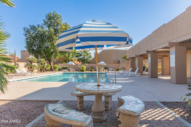 community pool featuring fence and a patio