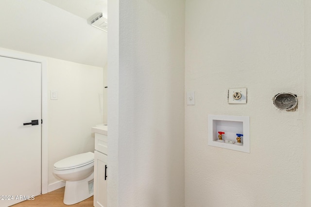 bathroom with toilet, wood finished floors, and vanity