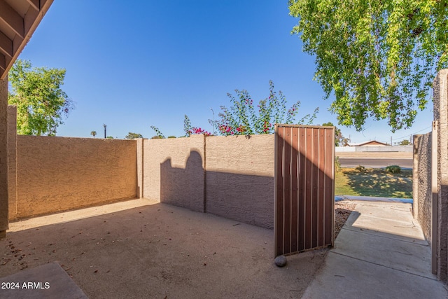 view of gate featuring a patio area and fence