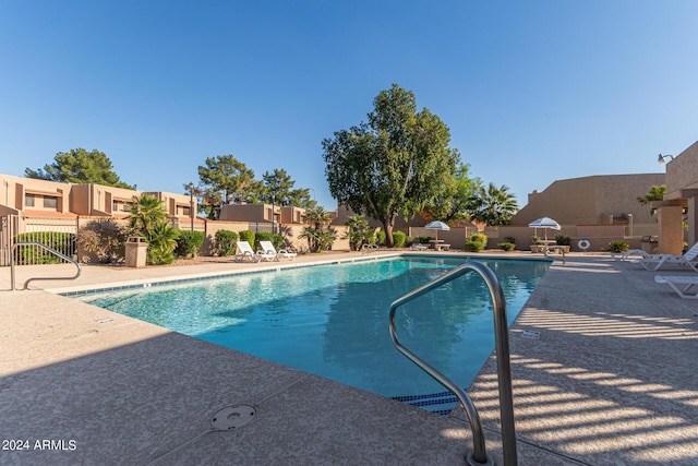 community pool with a patio area, a residential view, and fence