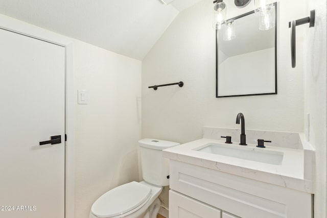 bathroom with lofted ceiling, vanity, and toilet