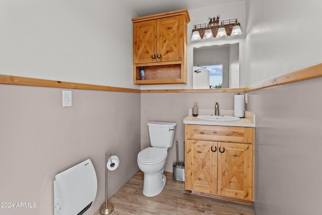 half bath with vanity, toilet, and wood finished floors