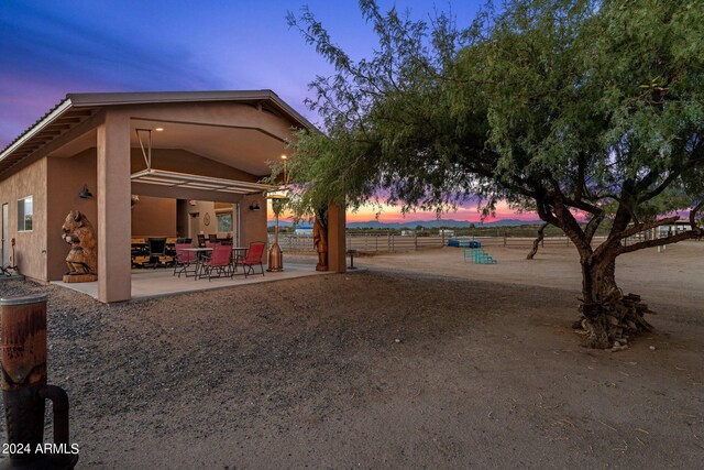 yard at dusk featuring a patio area