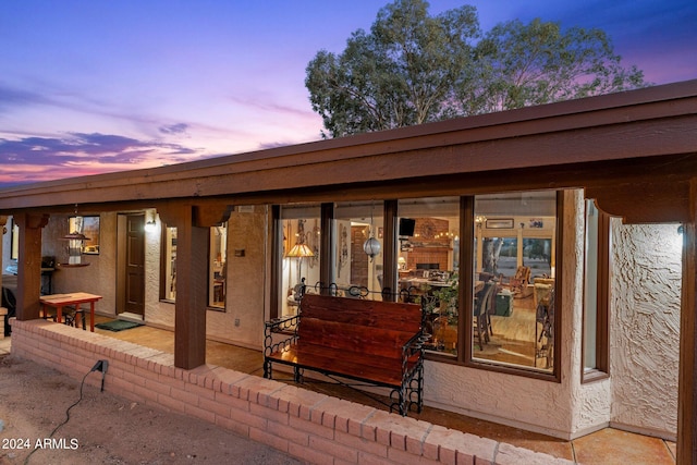 back of house at dusk with stucco siding