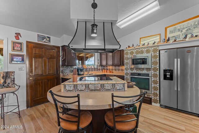 kitchen featuring appliances with stainless steel finishes, dark brown cabinets, tasteful backsplash, and light hardwood / wood-style floors