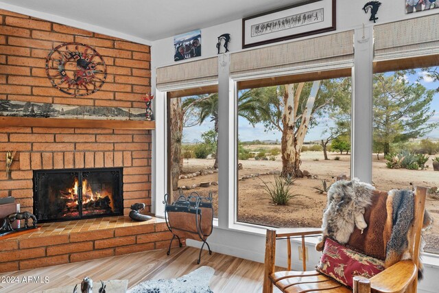 sitting room featuring hardwood / wood-style floors and a brick fireplace