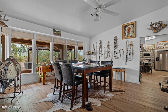 dining room with vaulted ceiling, wood finished floors, a ceiling fan, and baseboards