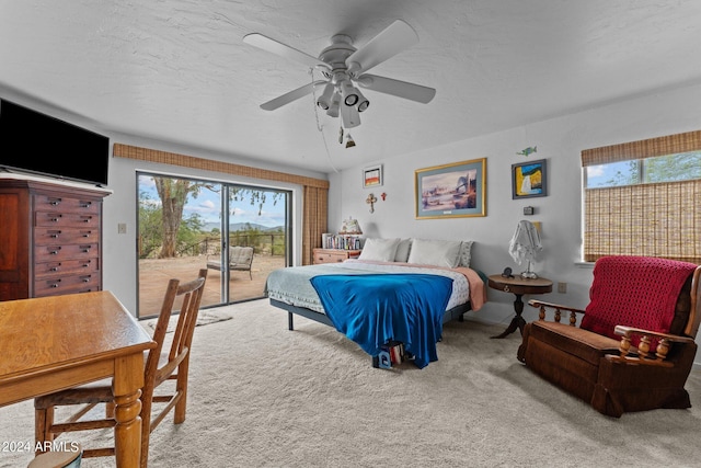 carpeted bedroom featuring access to exterior, ceiling fan, and a textured ceiling