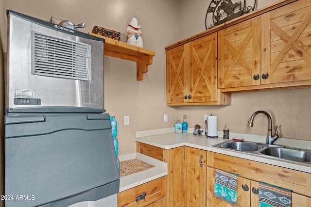 kitchen with fridge, light countertops, and a sink