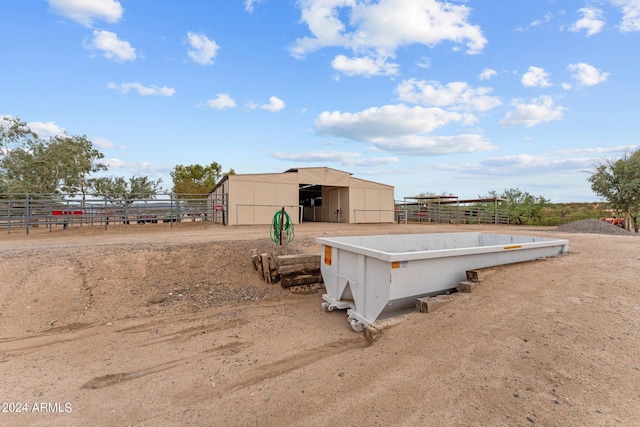 view of yard with an outbuilding, a pole building, an exterior structure, and fence