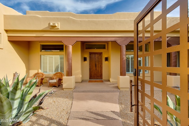 doorway to property featuring stucco siding