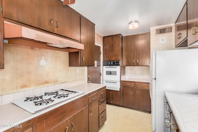 500 W Clarendon Ave Unit B11, Phoenix, AZ 85014 - kitchen featuring white appliances, a warming drawer, under cabinet range hood, tile countertops, and light floors