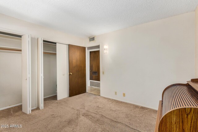 500 W Clarendon Ave Unit B11, Phoenix, AZ 85014 - bedroom with multiple closets, carpet flooring, and a textured ceiling