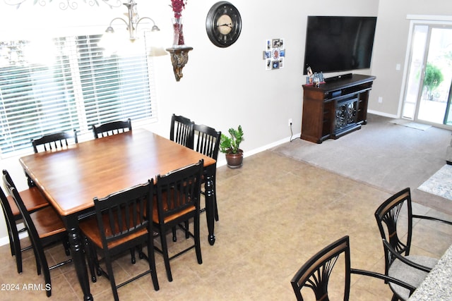 dining area featuring a notable chandelier and light colored carpet