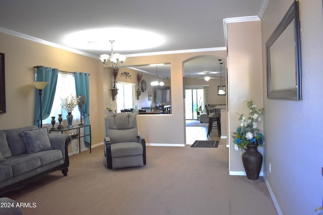 carpeted living room featuring ceiling fan with notable chandelier and crown molding