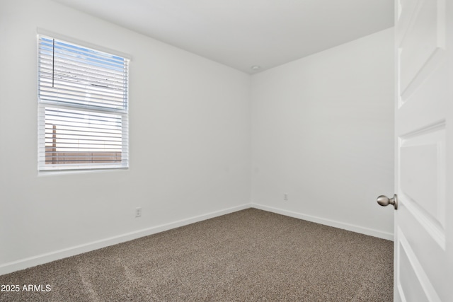 carpeted empty room featuring baseboards