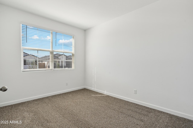 carpeted empty room featuring baseboards