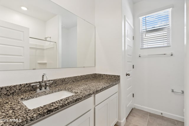 full bathroom with baseboards, walk in shower, tile patterned floors, and vanity