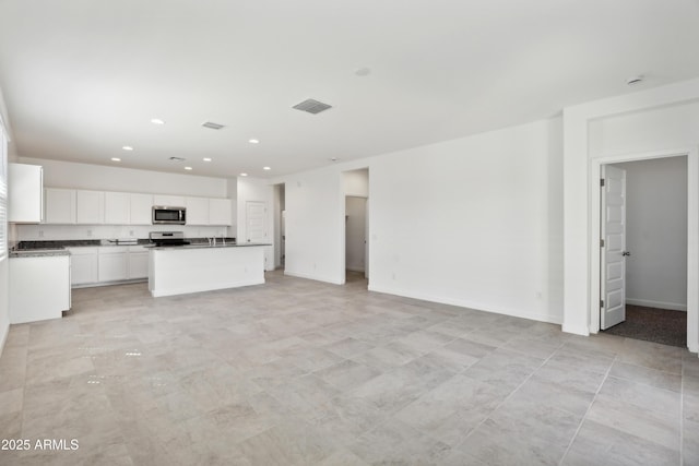 unfurnished living room featuring visible vents, light tile patterned floors, baseboards, a sink, and recessed lighting