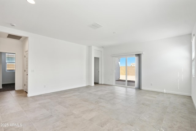 spare room with baseboards and visible vents