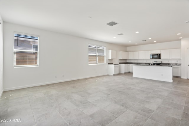 kitchen featuring visible vents, dark countertops, baseboards, recessed lighting, and stainless steel appliances