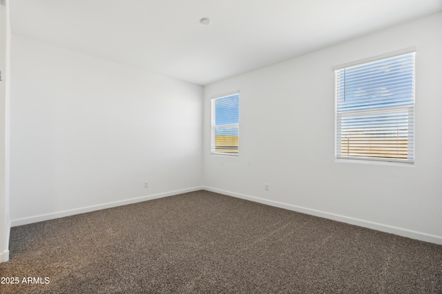 empty room with baseboards and dark carpet
