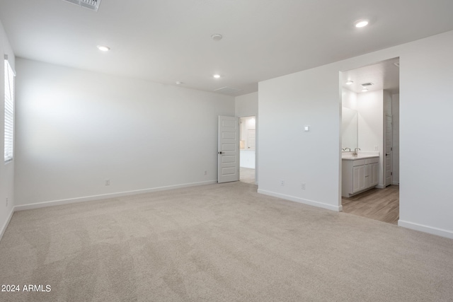 unfurnished room featuring light colored carpet