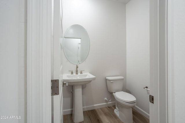 bathroom with toilet and wood-type flooring