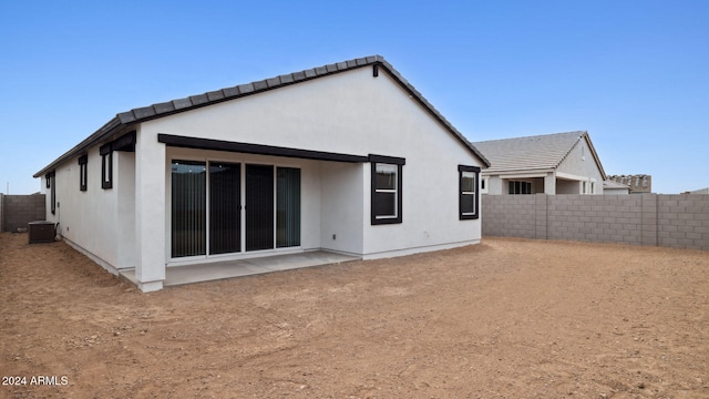 rear view of house with central air condition unit and a patio area