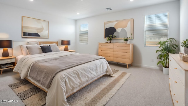 bedroom with light carpet and multiple windows