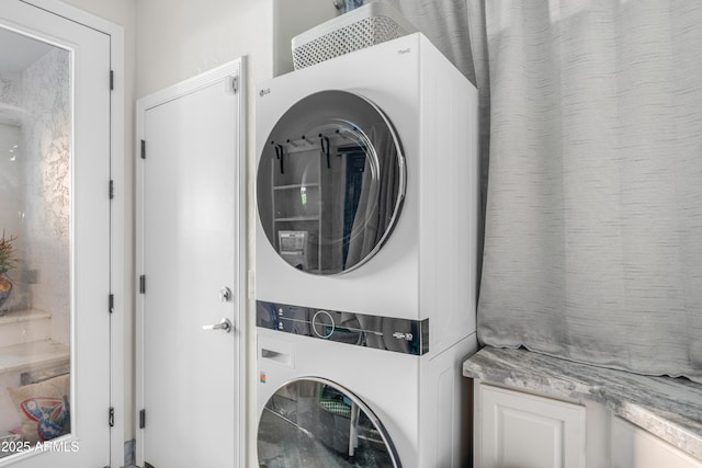 laundry area with stacked washer and dryer and laundry area